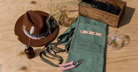 A collection of gardening tools and accessories displayed on a rustic wooden table for an earthy aesthetic.