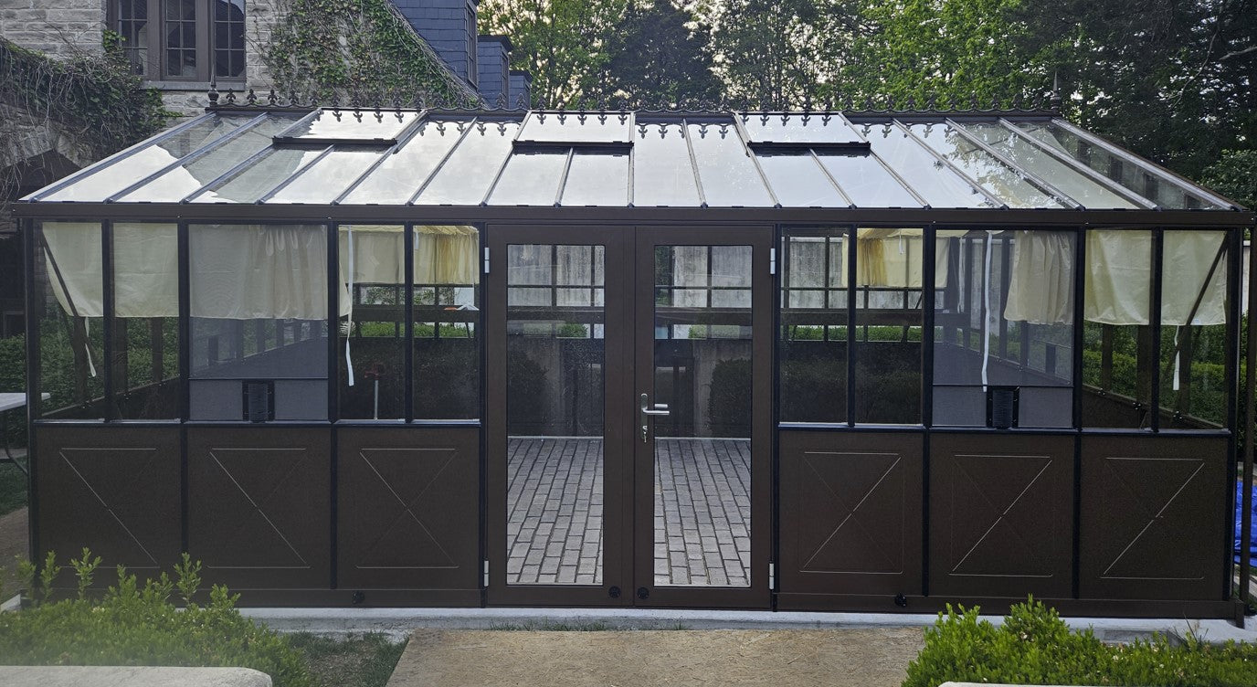 Retro greenhouse with glass panels and metal frame in a garden setting