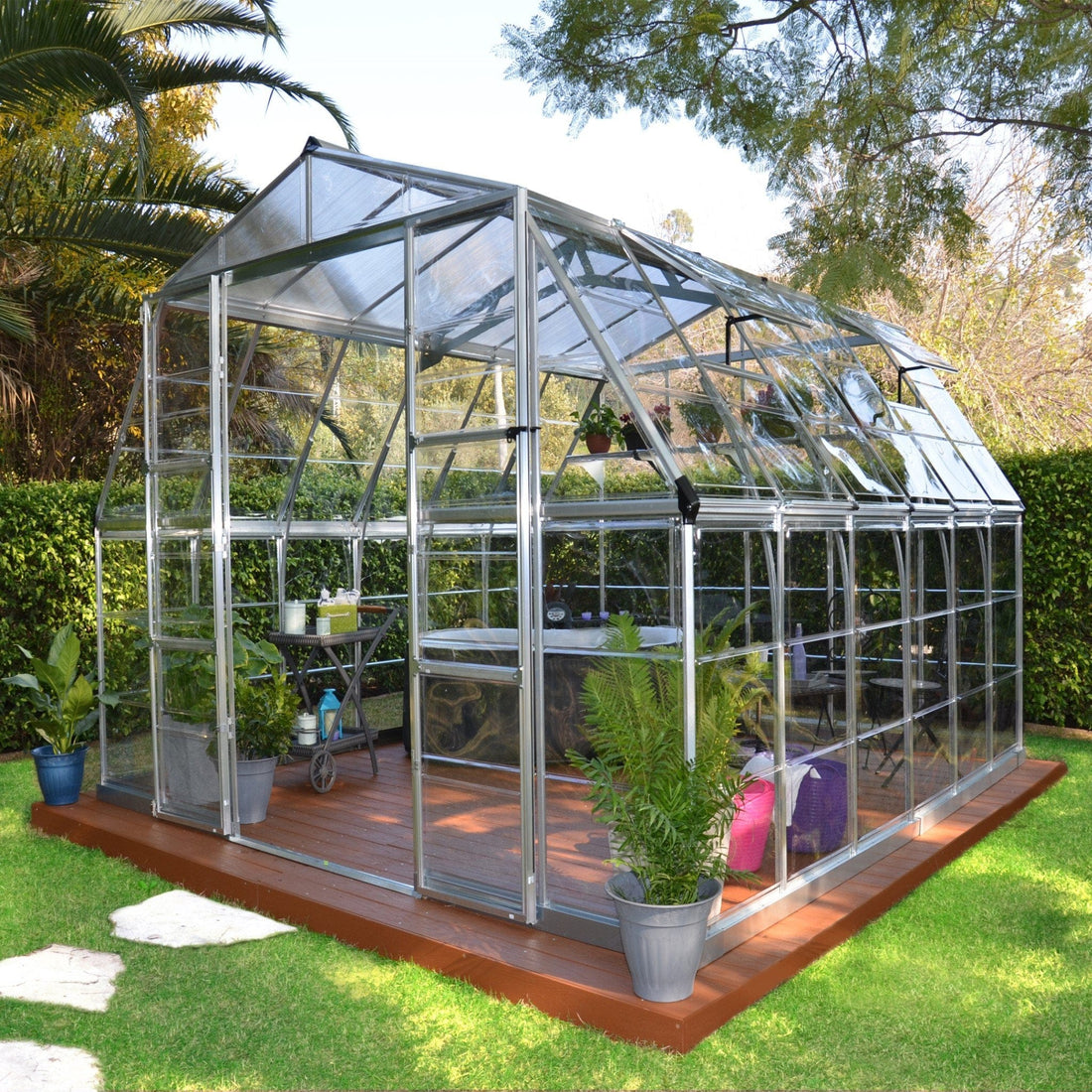 What are some of the properties and differences between acrylic and polycarbonate as a greenhouse glazing material?
