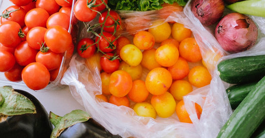A vibrant assortment of fresh vegetables including tomatoes, peppers, cucumbers, and lettuce displayed on a table.