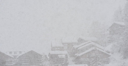 Severe scenery of remote rural village houses covered with thick layer of snow during intense snowstorm on cold winter day
